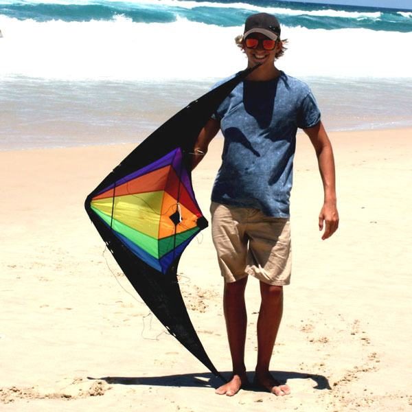 teenager holding Black Widow dual control kite on the sand
