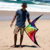 Teenager holding Prism stunt kite on the sand