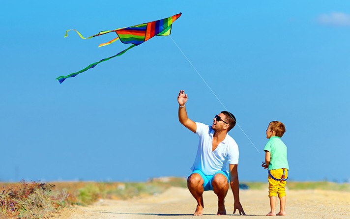 dad and son flying a delta kite