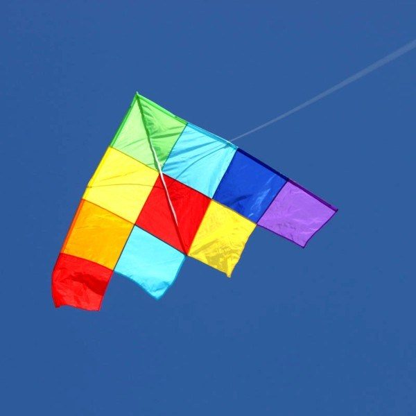 large single string delta kite with quilted patchwork pattern flying
