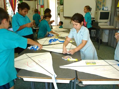 class mates helping each other make their kit kites