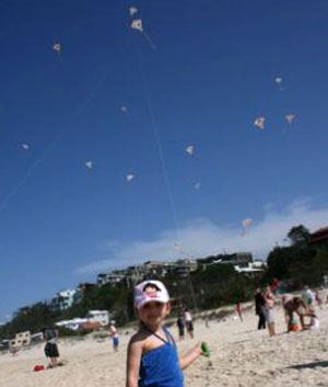 School children on the beach flying kites made in kite making workshop