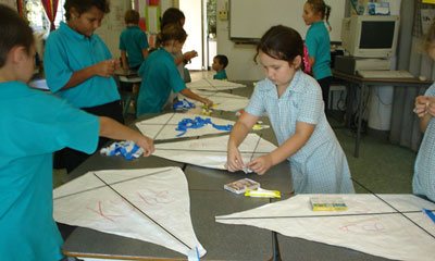class students make their kites in classroom