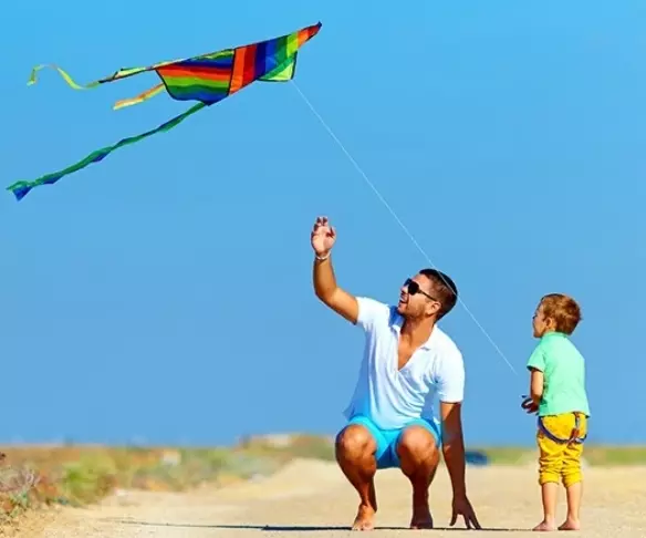dad and son flying a delta kite