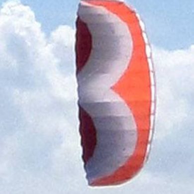 orange white and red Addict 2.4m parafoil stunt kite in flight