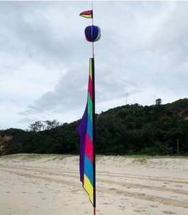 Pasatel coloured banner with spinning ball above it on a fiberglass pole