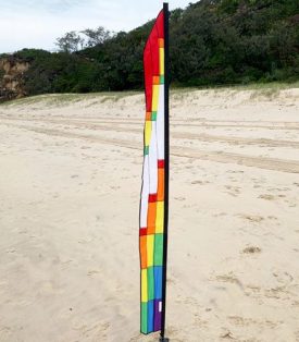 Rainbow coloured feather on the beach