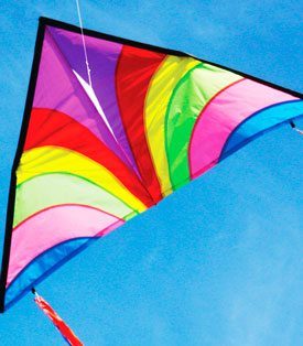 Bright delta shaped kite flying in a blue sky