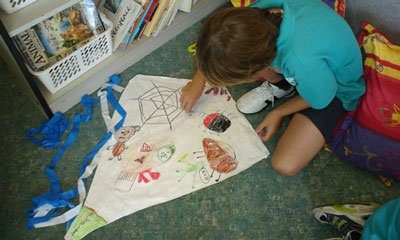 boy colouring in the kite he made in make your own kite making workshop
